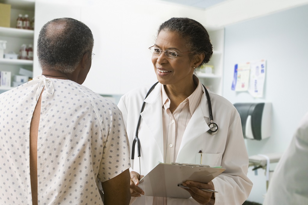 Black female doctor speaking to a Black male patient