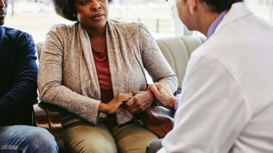 Doctor talking to older black female patient.