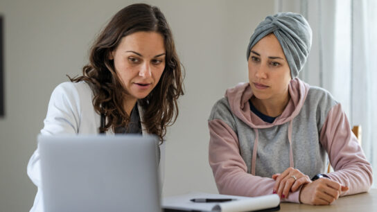 Doctor and cancer patient looking at a computer