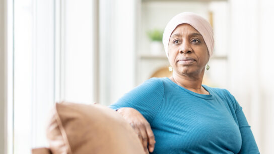 black older woman at home on couch wearing headscarf