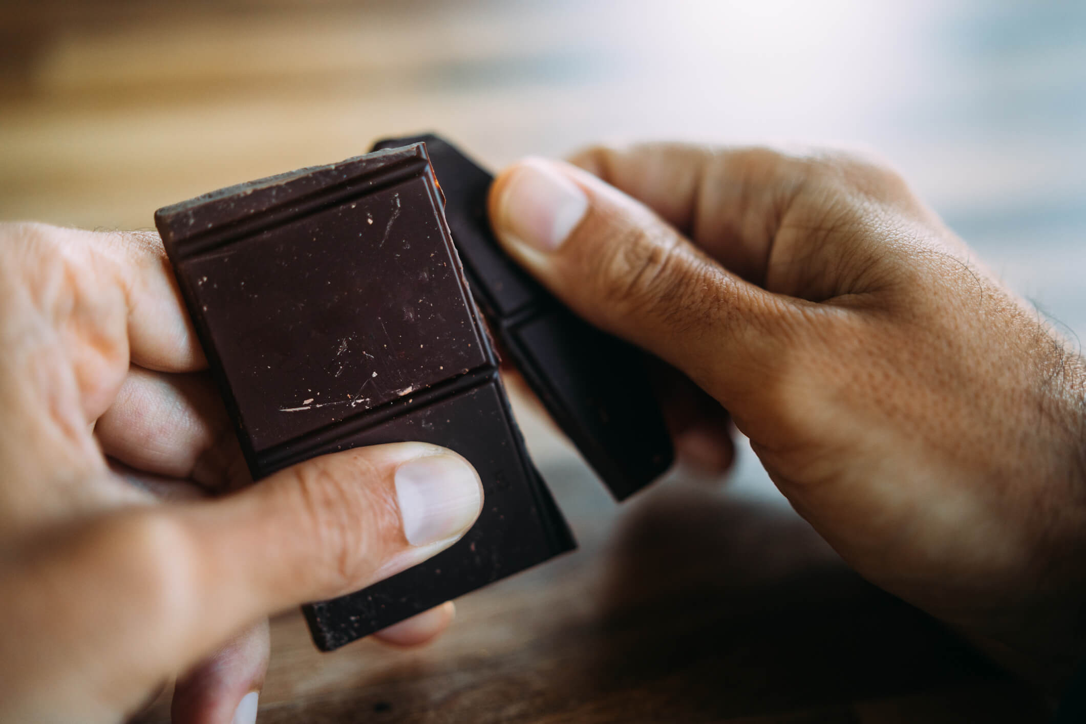 Person breaking off piece of chocolate.