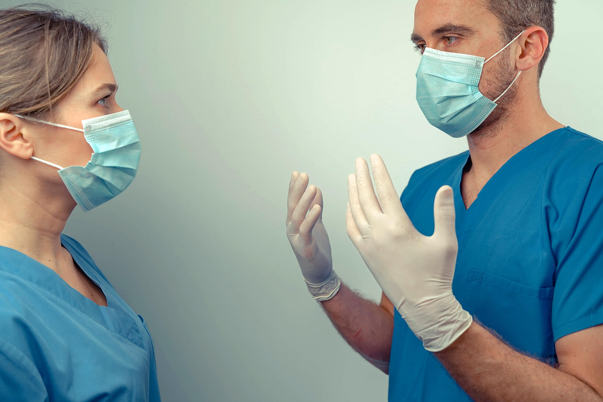 Masked medical workers discuss patient care.