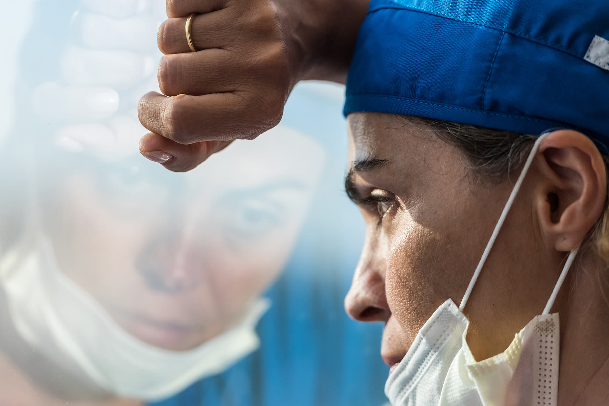 Overworked healthcare worker looking through a window.