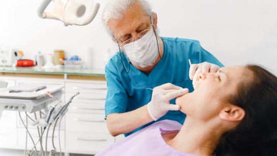 Administering an exam of the oral cavity.