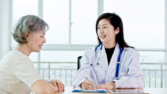 Female doctor talking to senior patient.