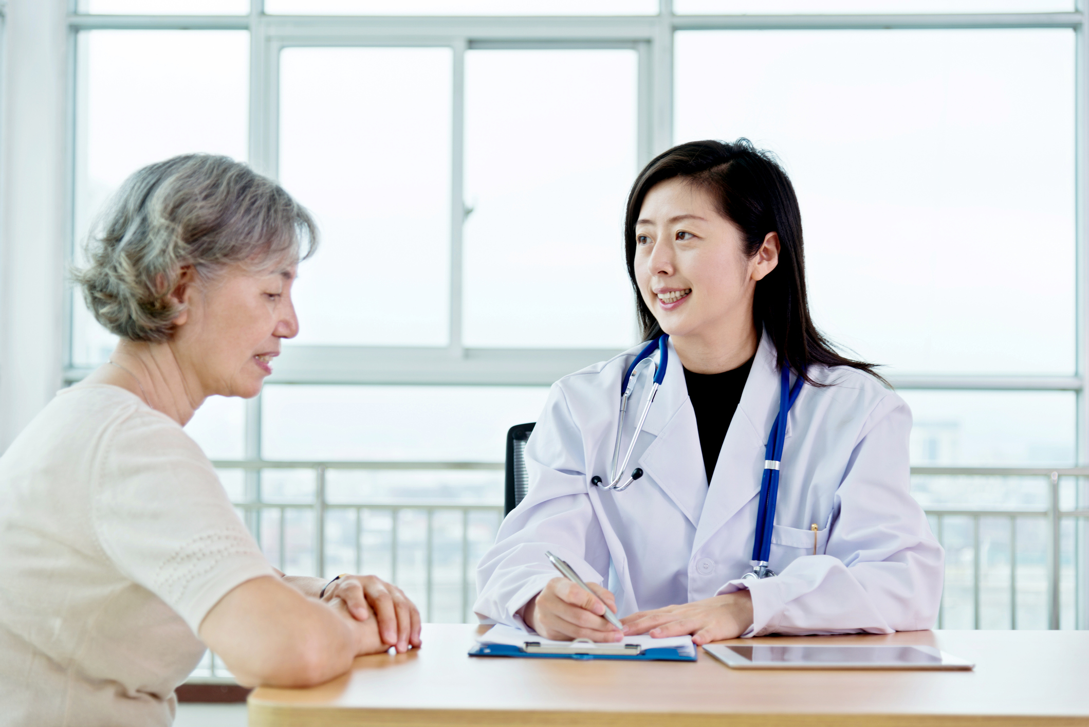 Female doctor talking to senior patient.