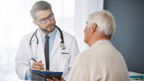 Shot of a young male doctor talking with older male patient