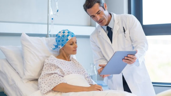 Patient in hospital bed talking to doctor.