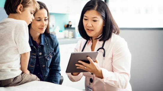 Doctor showing tablet to child