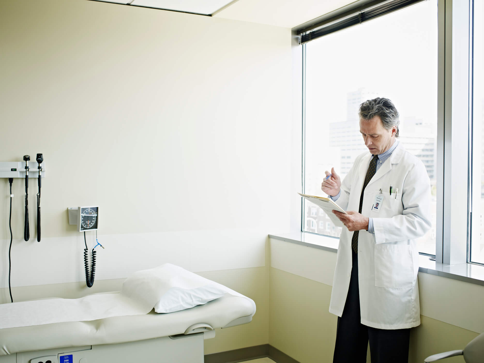 Doctor reading in exam room.