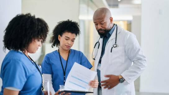 Doctor and nurses looking at chart.