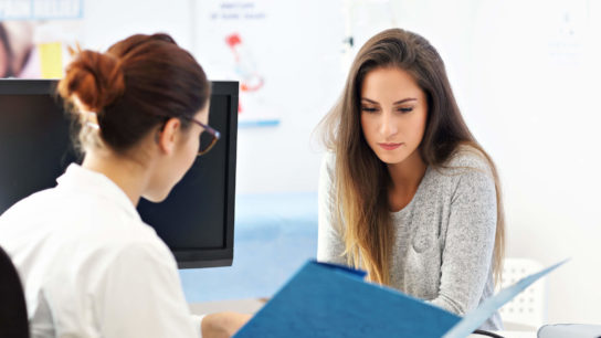 Female patient talking to doctor.