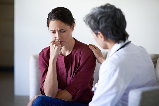 A nurse consoles a caregiver.