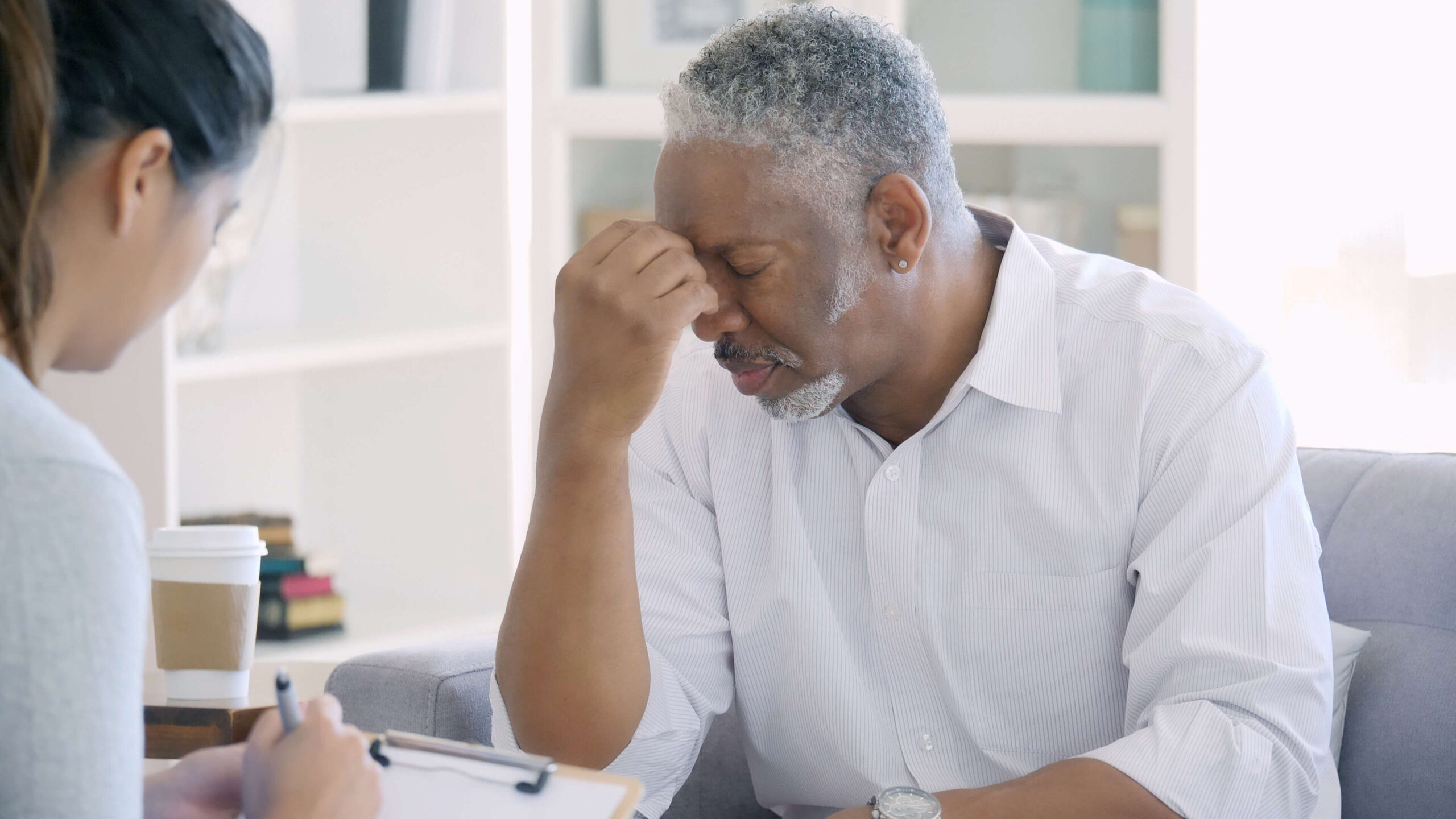 Black male patient looking distressed in front of doctor.