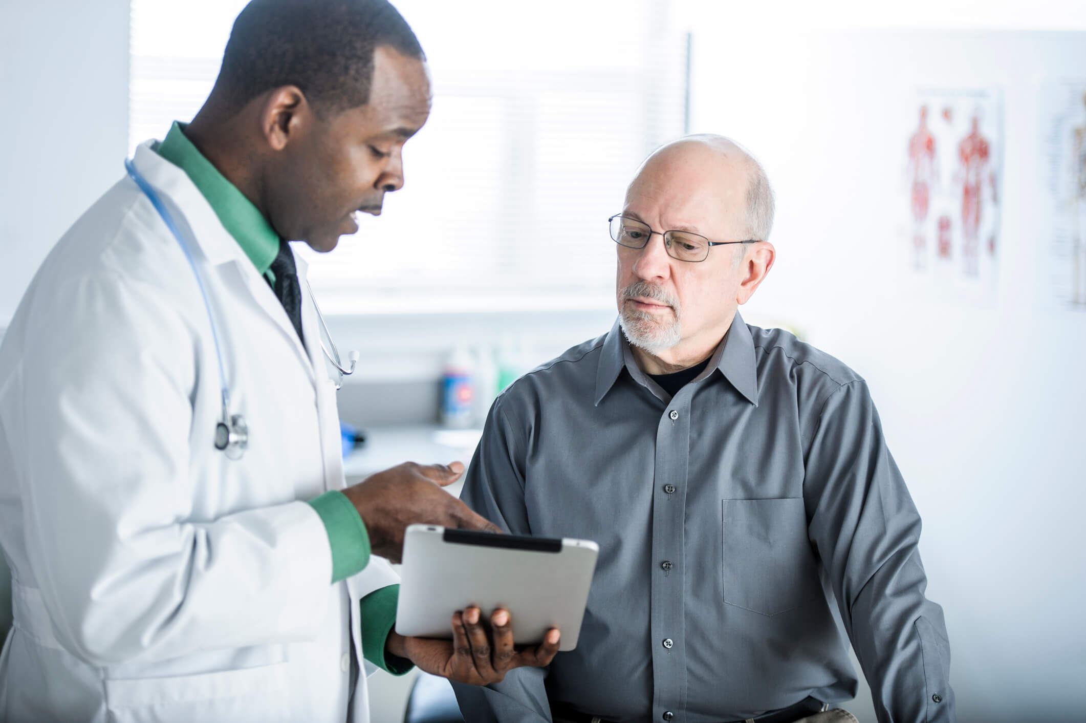 Doctor showing tablet to patient.