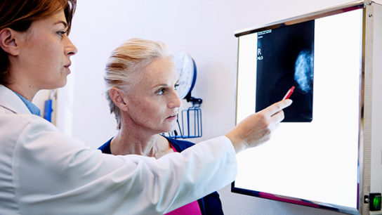 A patient and clinician review mammography results.