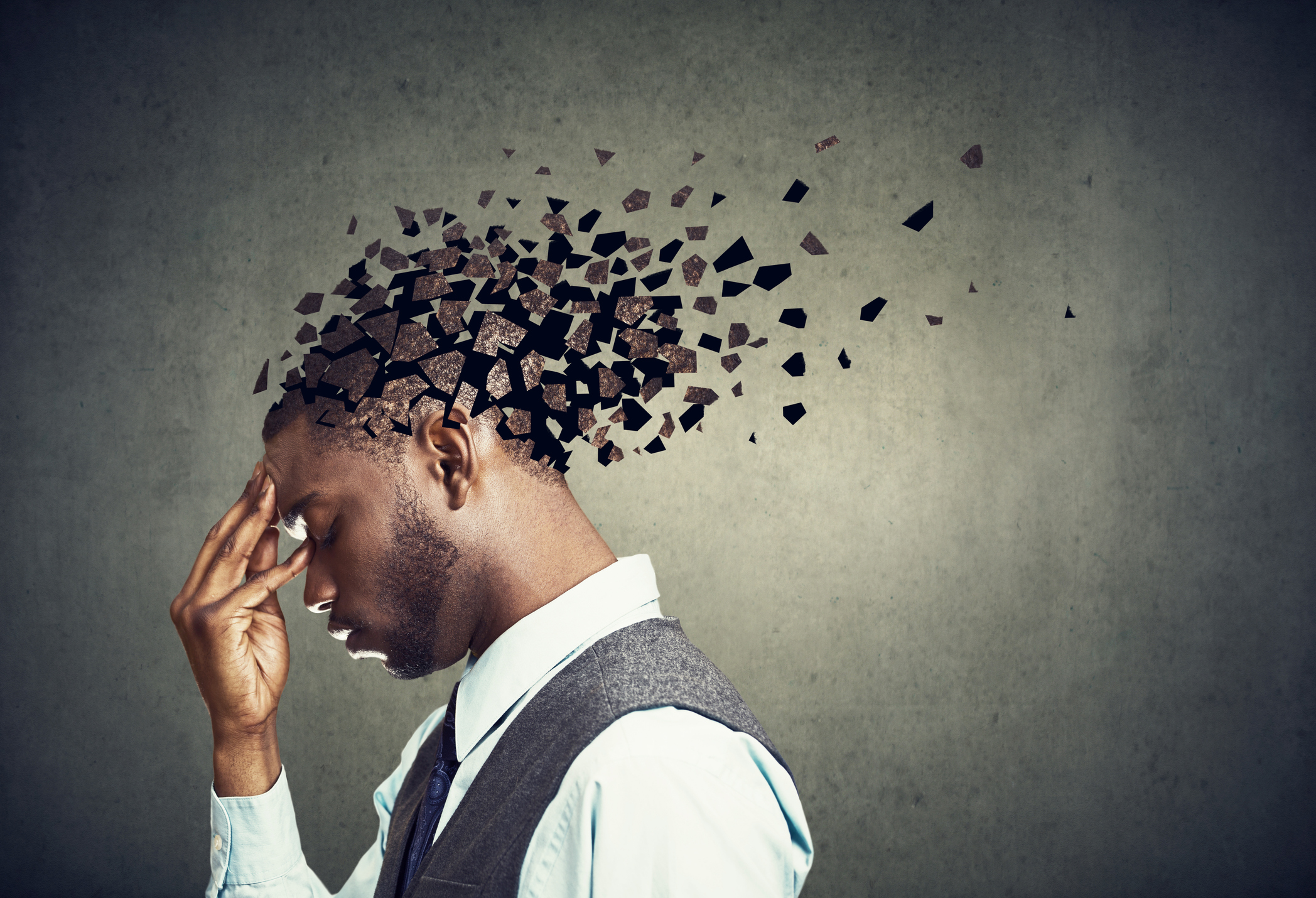 Side profile of a sad man losing parts of head as symbol of decreased cognitive function.