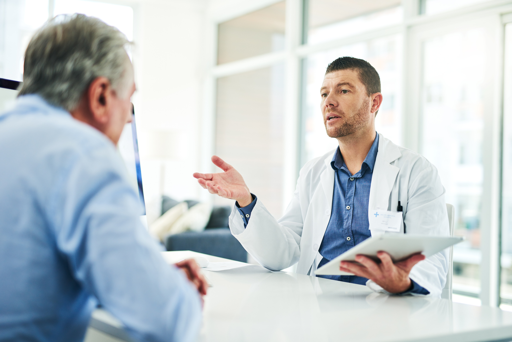 Cropped shot of a focused middle aged doctor consoling with a patient inside of his office during the day