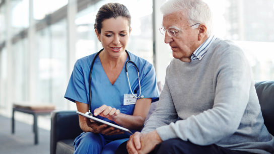 A nurse navigator discusses upcoming treatment plans with a patient.