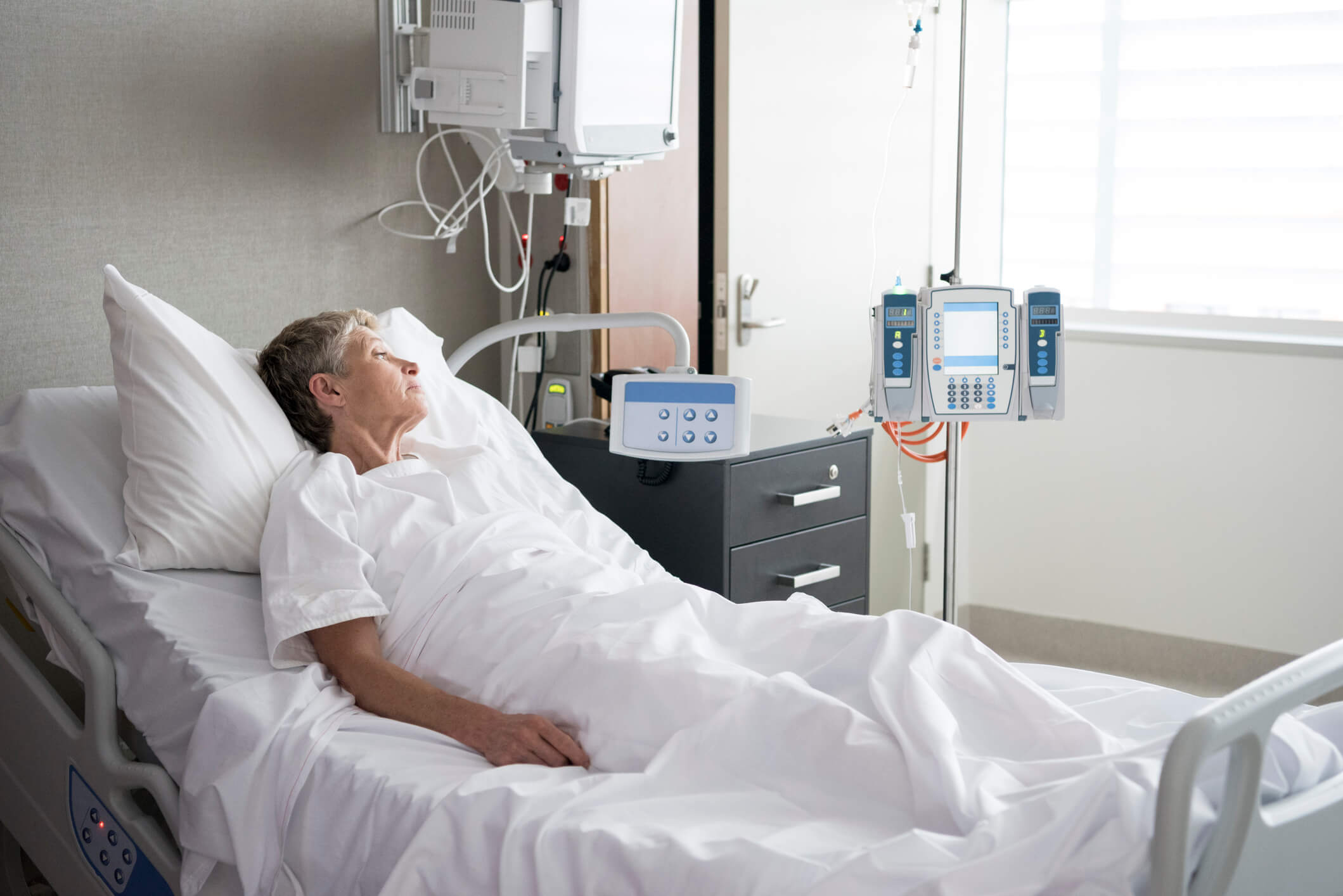 Older female patient in hospital bed.