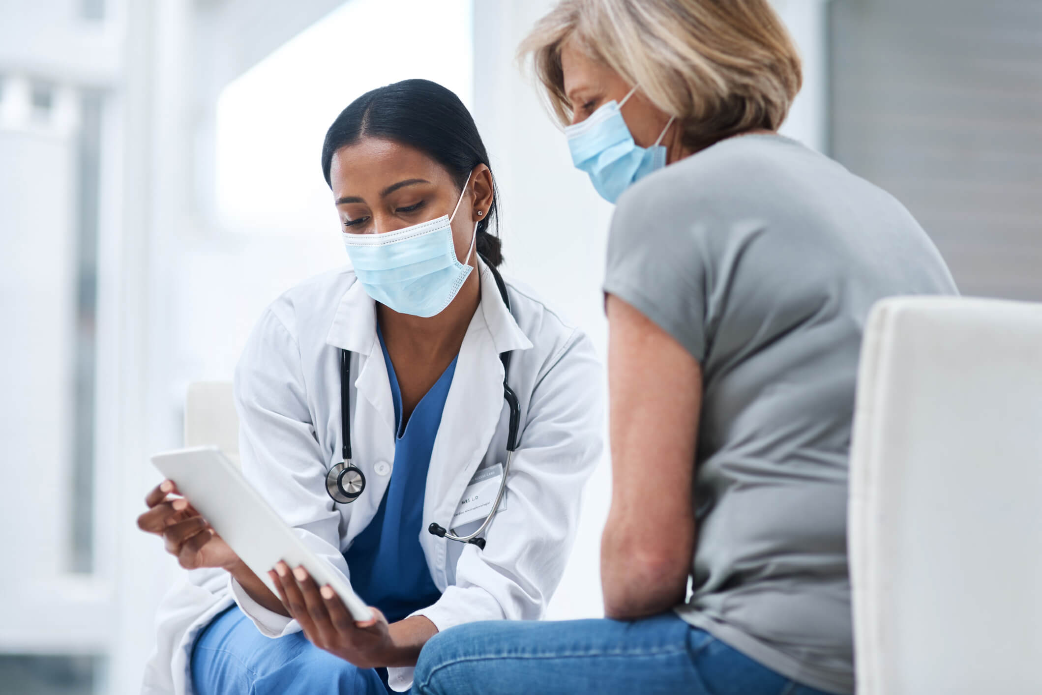 Doctor showing tablet to patient.