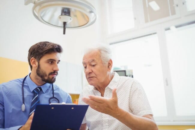 An elderly patient speaks with a doctor.