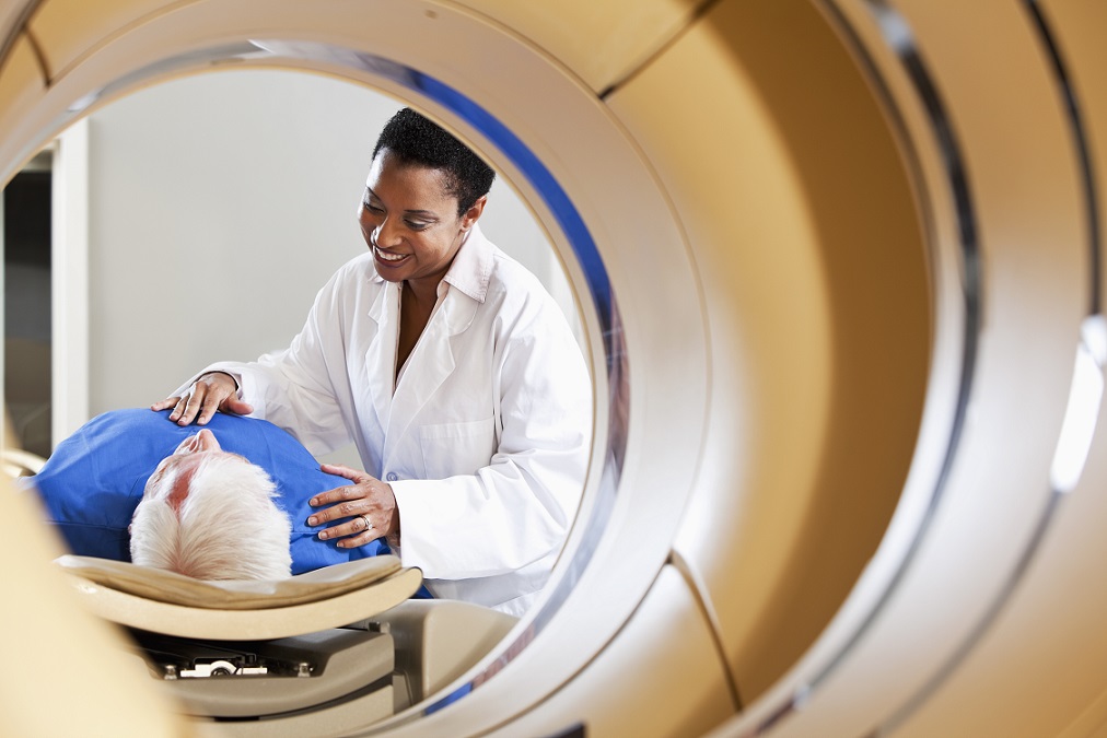 Radiologist preparing patient for PET-CT scanner.