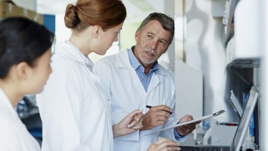 Research team lab coats discussing results