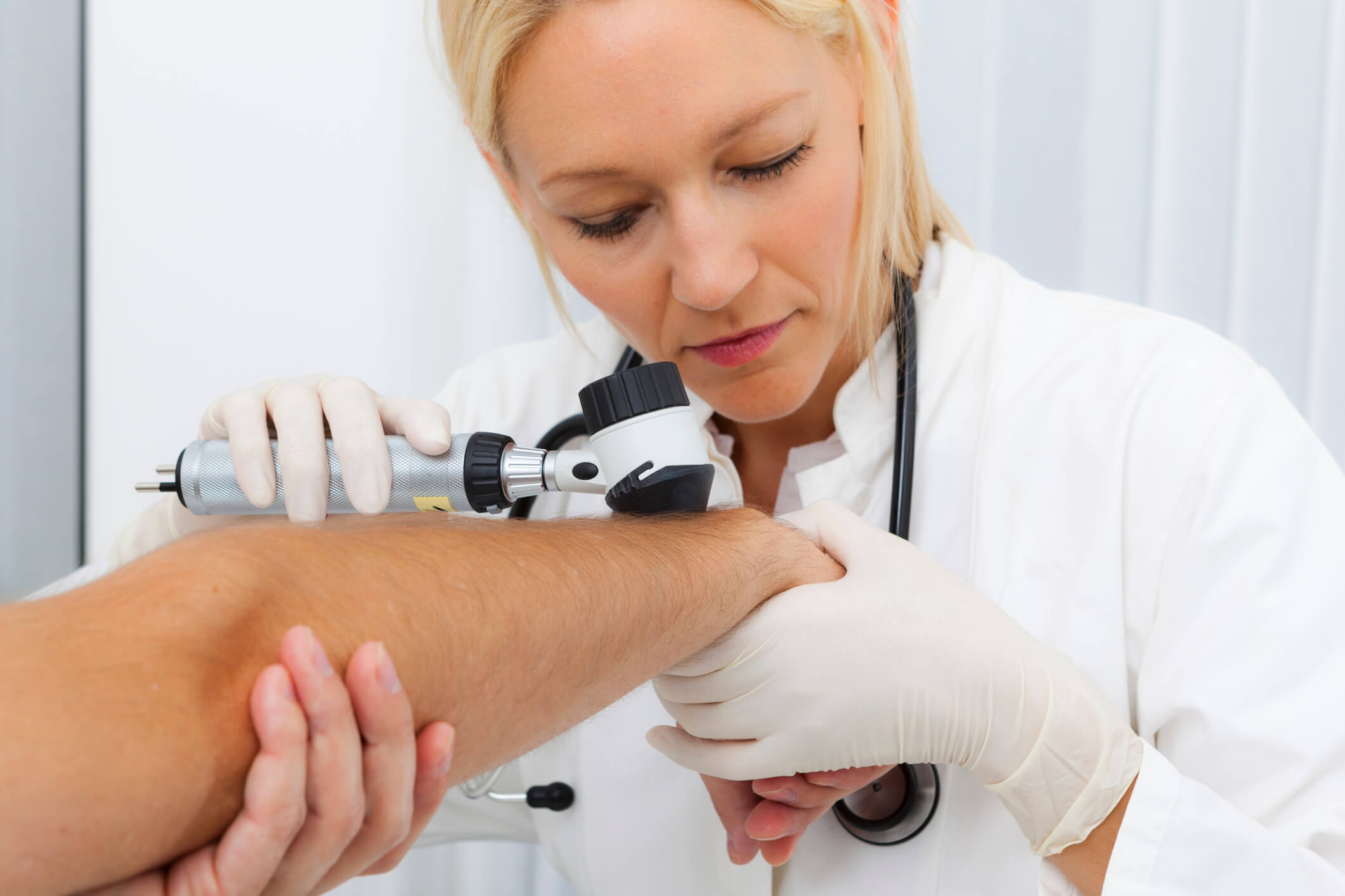 Doctor examining patient's skin.