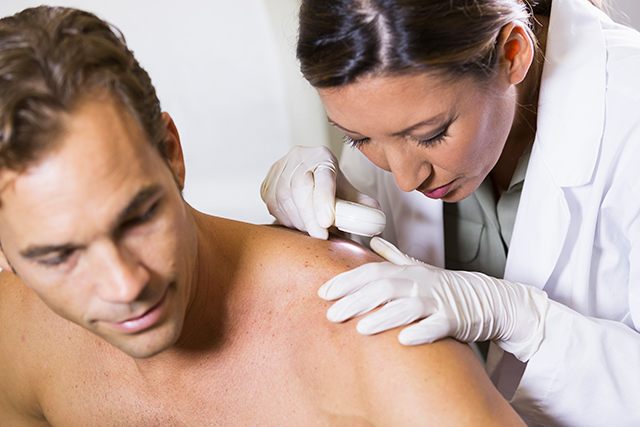 Dermatologist examines a patient's skin for signs of skin cancer.