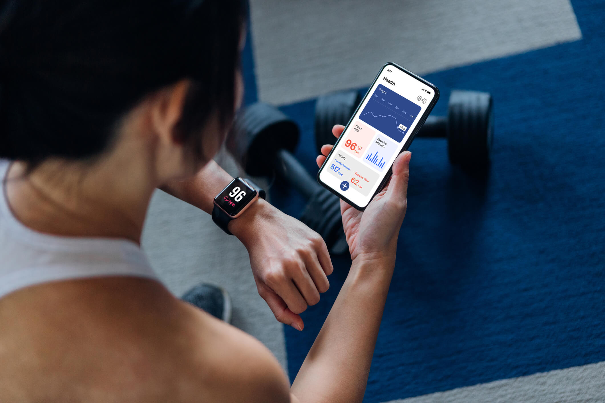 Young woman looking at exercise app on smartphone.