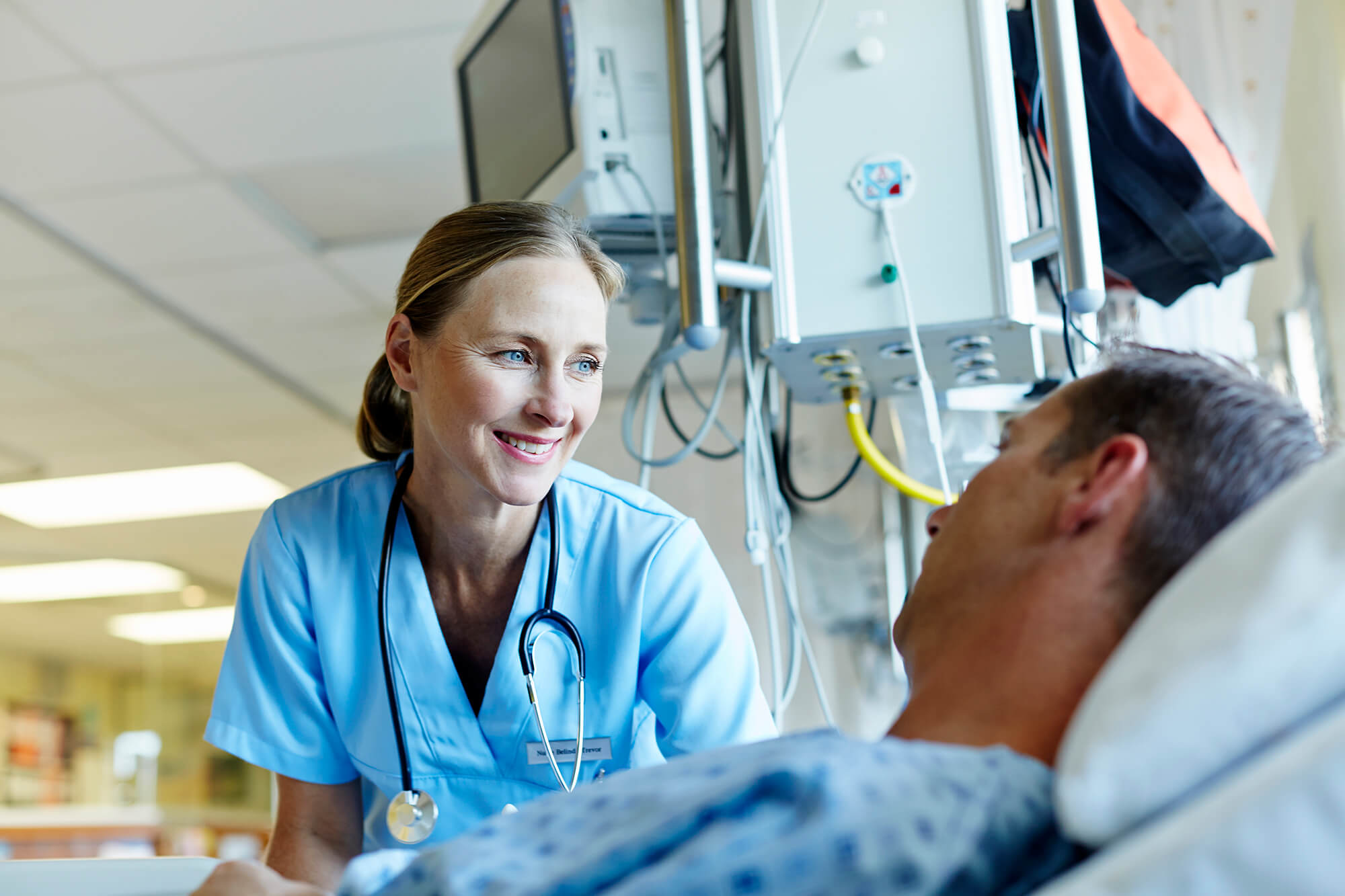 A nurse evaluates a patient post-surgery.