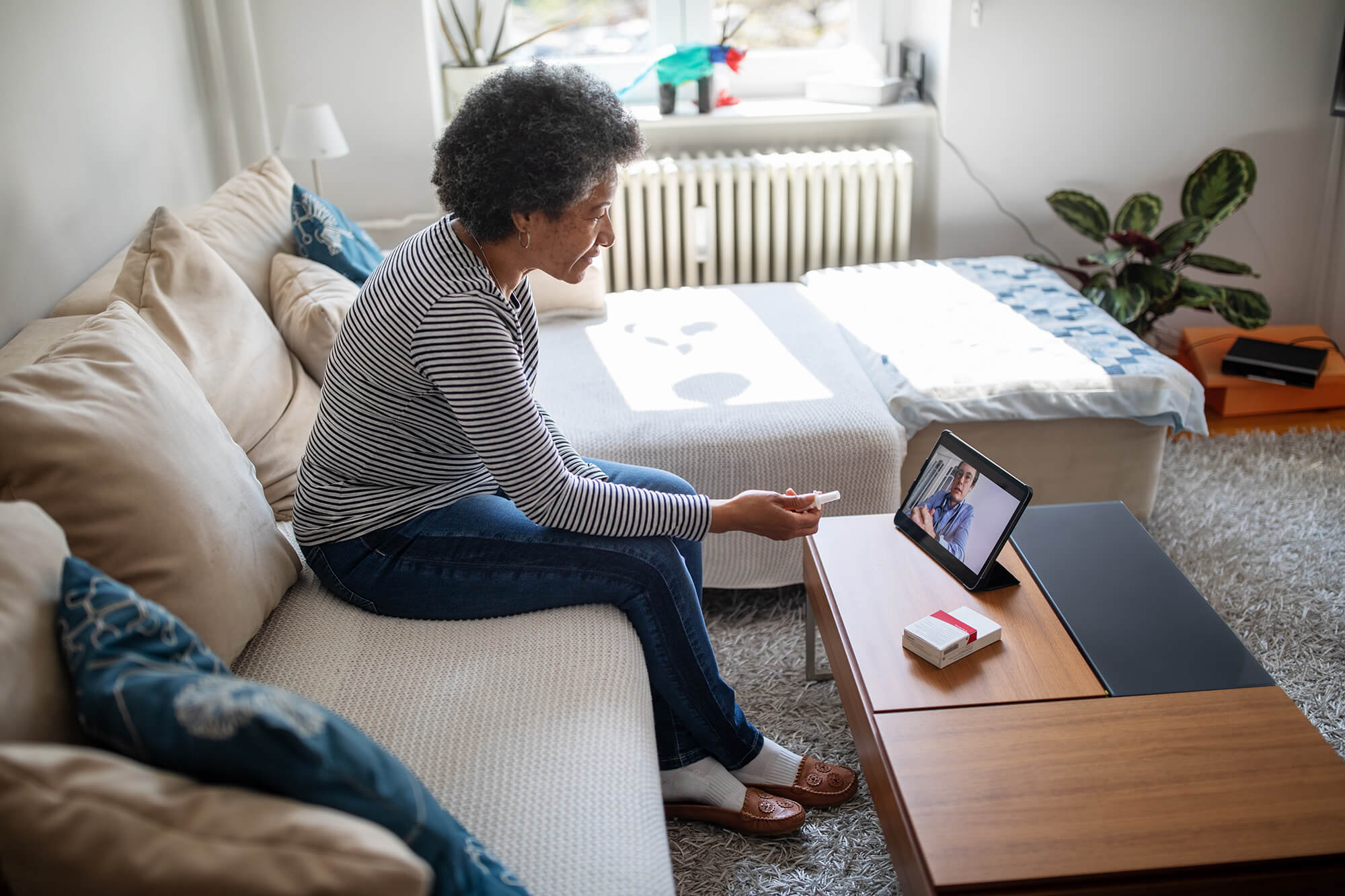 A cancer survivor is contacted by a clincian remotely.