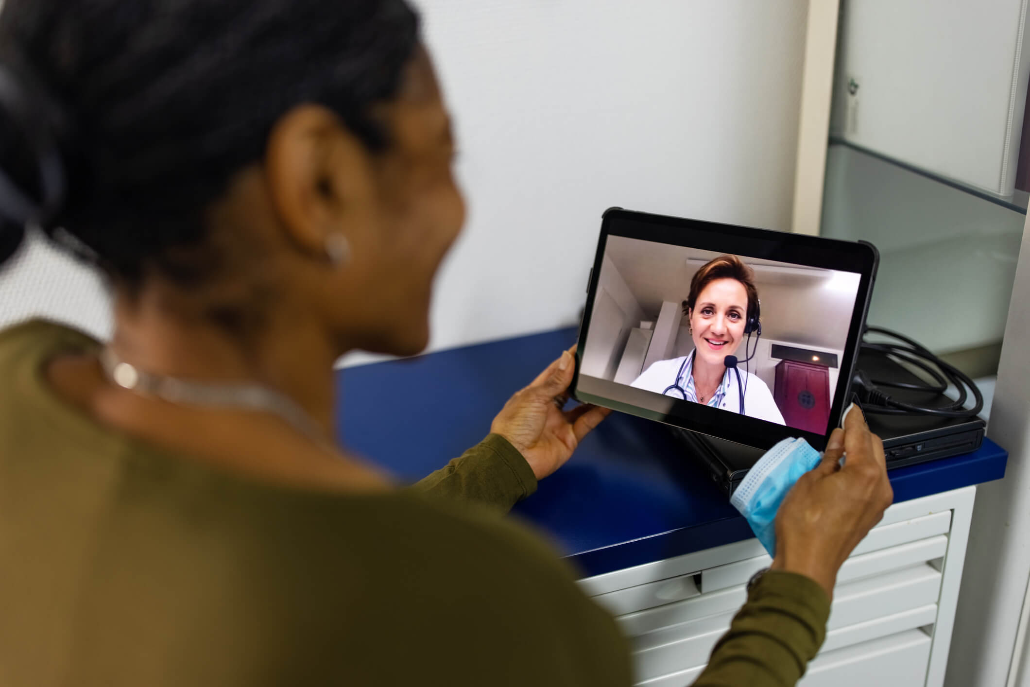 Image of woman talking to doctor through tablet.