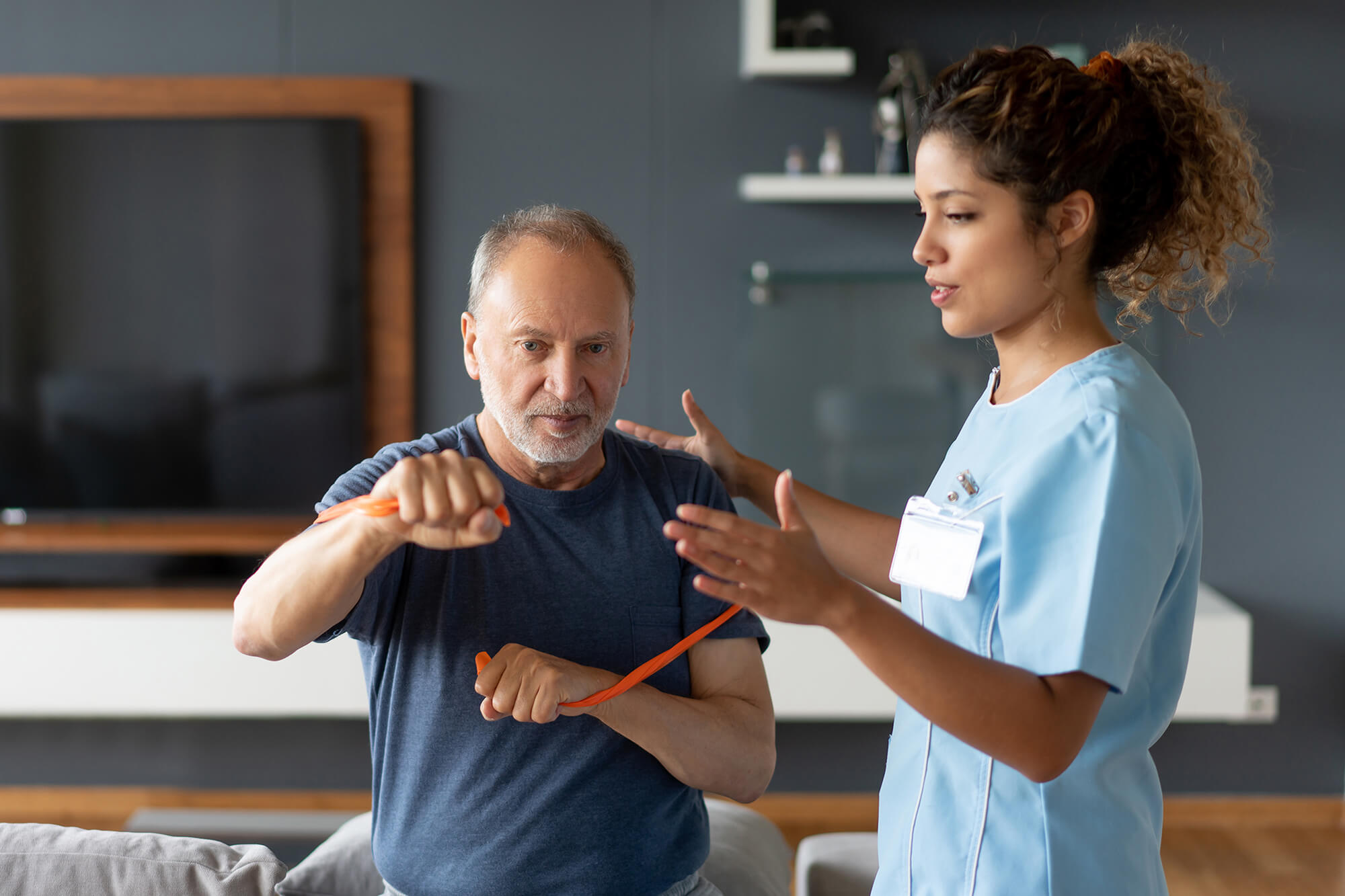 Helping a senior patient with his physiotherapy