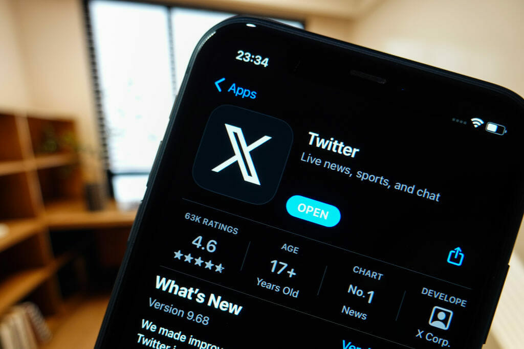 TheTwitter "X" app's new logo is displayed on the screen of a smartphone.