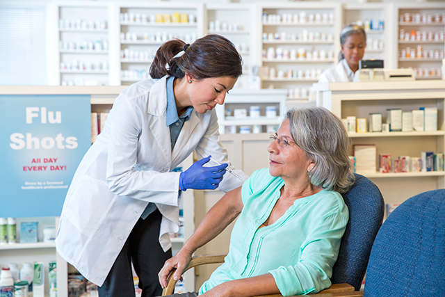 A pharmacist administers a flu shot.