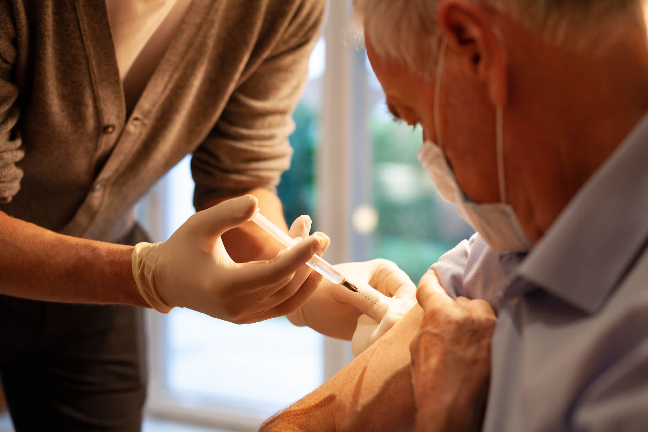 Elderly male patient getting vaccinated.