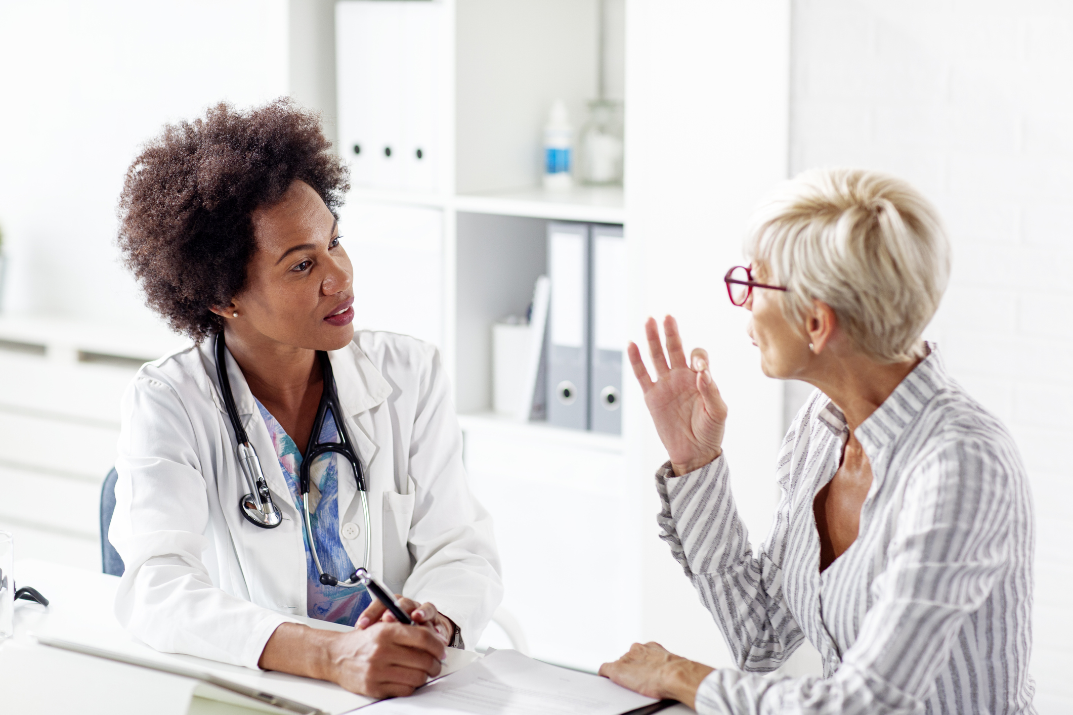 Older woman talking with her doctor about health in clinic