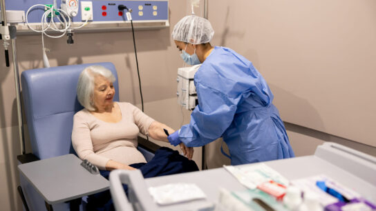 Nurse preparing cancer patient to receive an infusion