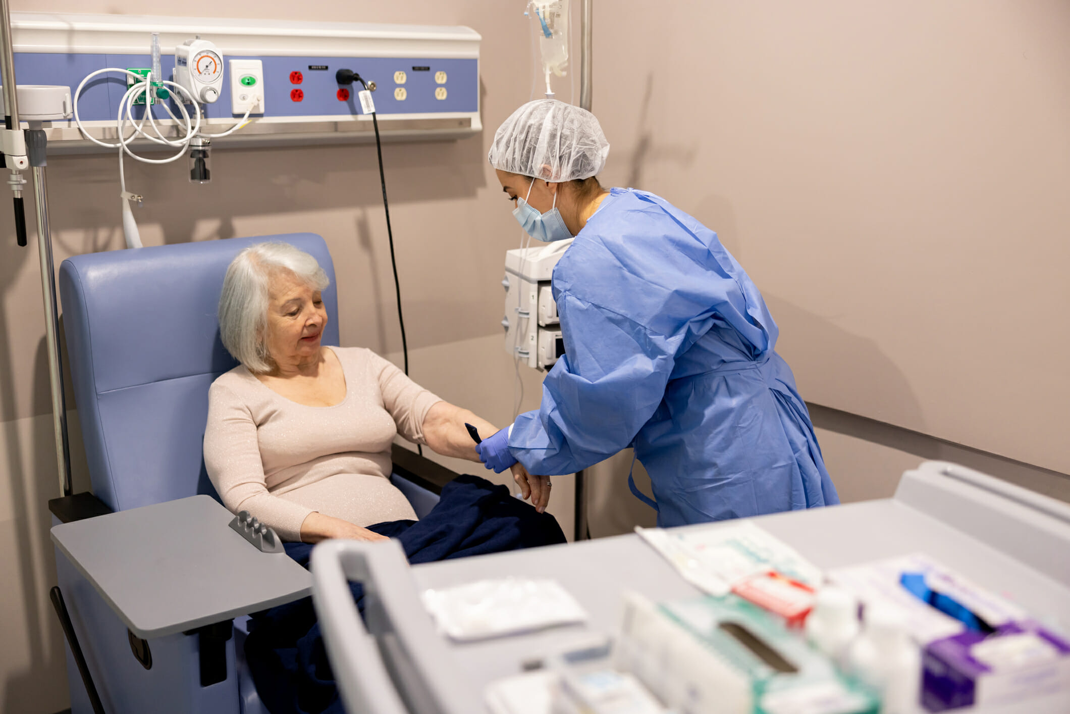 Nurse preparing cancer patient to receive an infusion